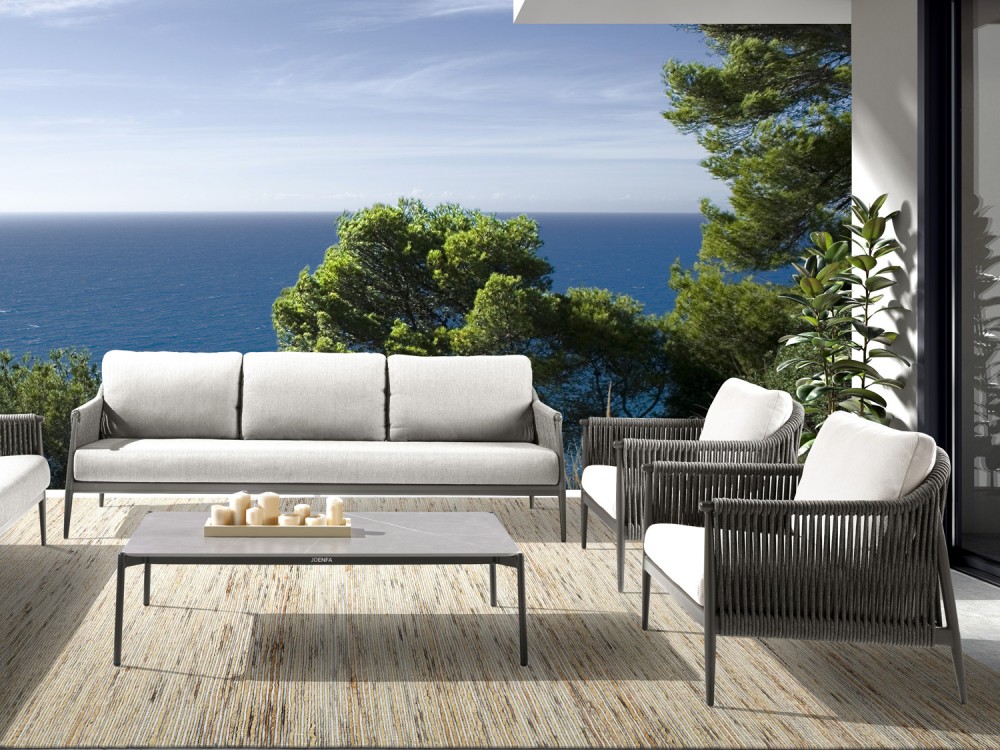 Mesa de centro de exterior con patas de aluminio y superficie en piedra sinterizada gris, estilo contemporáneo.