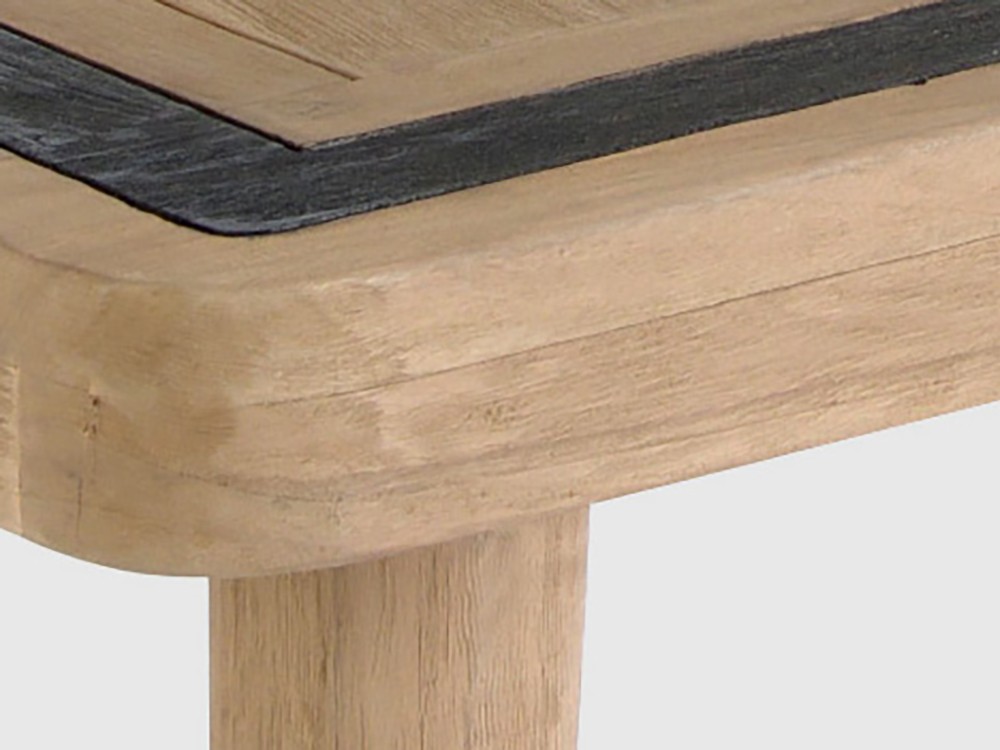 Detalle de la superficie de la mesa Desire, mostrando la textura de la teca y el borde distintivo en tono oscuro