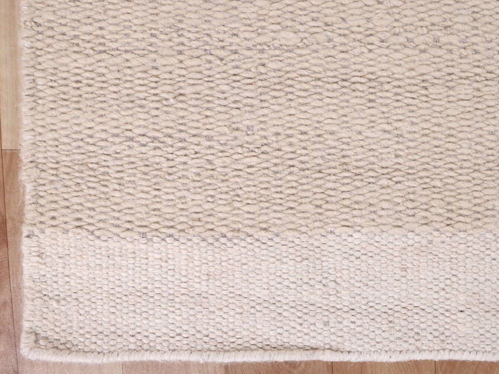 Alfombra de lana y algodón tejido a mano en color marfil