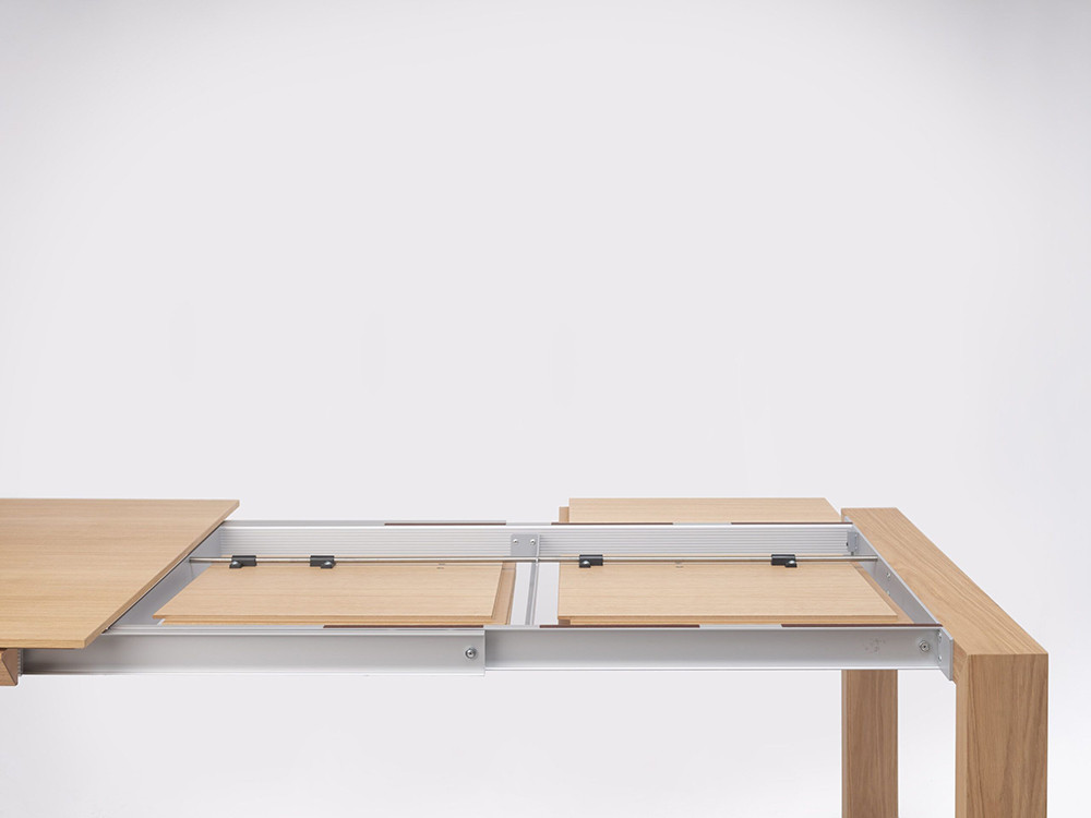 Detalle de la chapa de roble tintado de la mesa extensible Iru de Ondarreta en ambiente de comedor